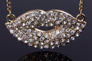 Gold tone kiss necklace