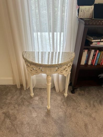 ornate half-moon console table with a granite top