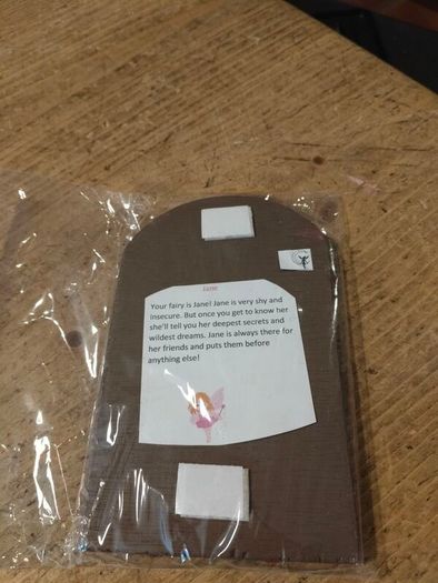 handcrafted wooden  Fairy door with red cardstock, brown flower cutouts, and decorative buttons.  various buttons acting as handles or embellishments.