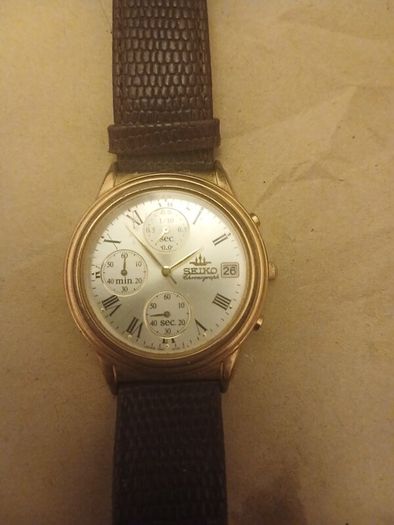 This is a gold-tone Seiko Vintage V657-8110 quartz chronograph watch featuring a cream dial with Roman numerals and three sub-dials