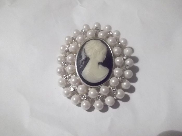 a costome jewelley brooch with cameo and pearls