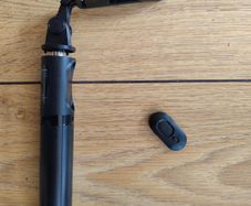 black extendable selfie stick and mini-tripod featuring a detachable wireless Bluetooth remote.