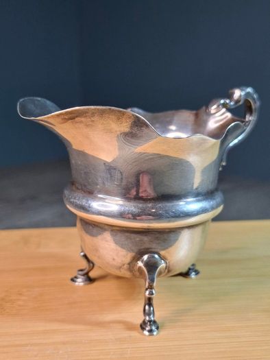 Antique silver cream jug with scalloped rim