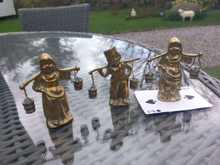 3 brass figures with water buckets, D18 post 7e