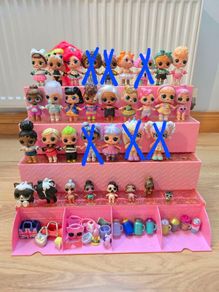 A lot of L.O.L. Surprise dolls with accessories and a doll podium.