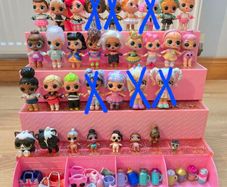 A lot of L.O.L. Surprise dolls with accessories and a doll podium.