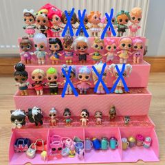 A lot of L.O.L. Surprise dolls with accessories and a doll podium.
