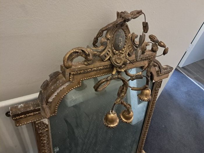 Two distinct antique giltwood mirrors with elaborate French-style ornamentation