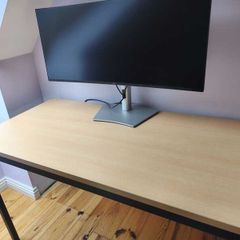 Modern desk with light wood top and black metal frame