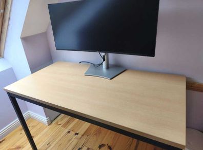 Modern desk with light wood top and black metal frame