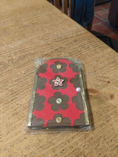 handcrafted wooden  Fairy door with red cardstock, brown flower cutouts, and decorative buttons.  various buttons acting as handles or embellishments.