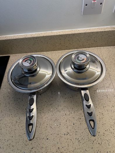 stainless steel saucepans featuring "Thermo Control" knobs on the lids