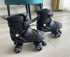 Power adjustable black quad roller skates