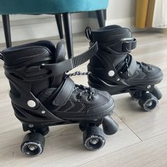 Power adjustable black quad roller skates