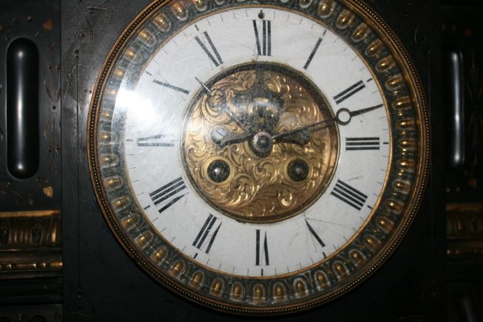 Victorian French Black Slate Mantle Clock (Very large and heavy) with bronze ornamentation Oversized. Open escarpment slate plate Roman numerals. Circa 1890s. Accented with Trojan head. Flanked by two Hellenistic ladies heads on sides. Rose cartouche mask