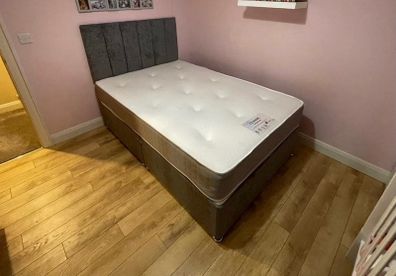 Grey double bed with mattress