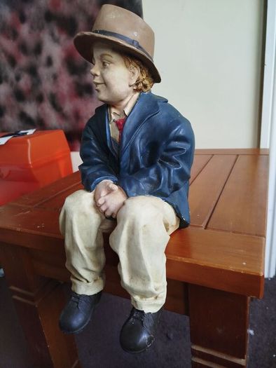Resin sculpture of a seated boy