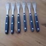 A 12-piece stainless steel steak knife and fork set with wooden riveted handles. Image 6