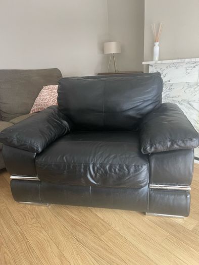 black Leather Armchair featuring plush pillow top arms and chrome accent feet need gone ASAP due to house clearance