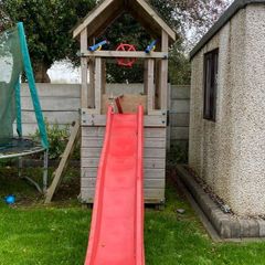wooden tower with slide, climbing wall, underneath den, ladder, steering wheel and 2 pirate lookout's
