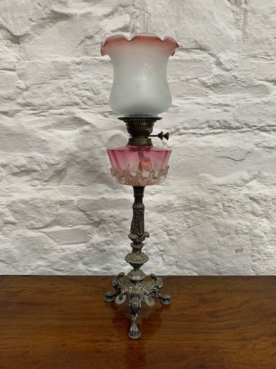 Early Edwardian oil lamp with cast metal base.