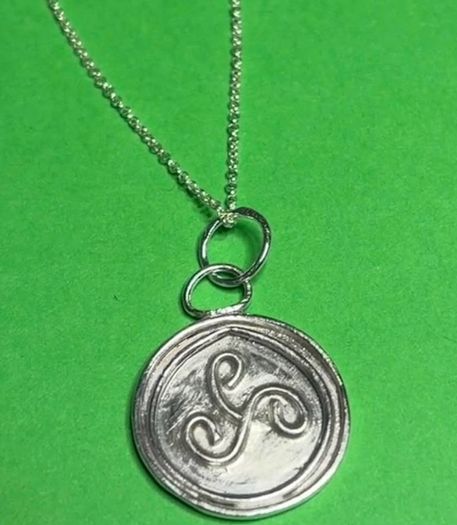 Sterling silver Triskele pendant with 18 inch chain.
