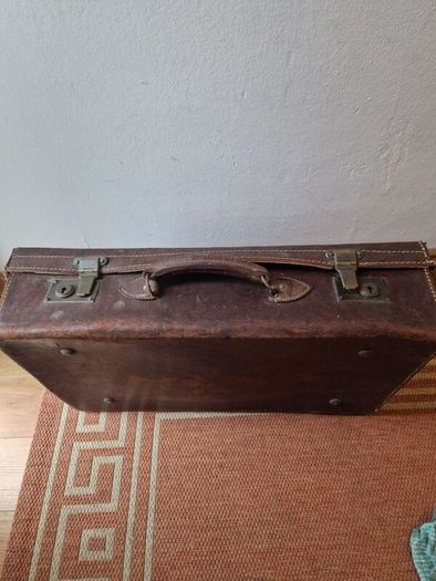 1leather suitcase and 1 faux leather suitcase.