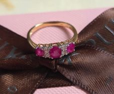 Beautiful yellow gold ring featuring three stunning rubies surrounded by sparkling cubic zirconia stones. Size M, in beautiful condition.