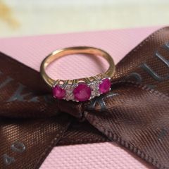Beautiful yellow gold ring featuring three stunning rubies surrounded by sparkling cubic zirconia stones. Size M, in beautiful condition.