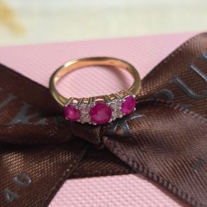 Beautiful yellow gold ring featuring three stunning rubies surrounded by sparkling cubic zirconia stones. Size M, in beautiful condition.
