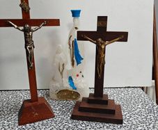 Two crucifixes and a Lourdes Our Lady holy water bottle. Religious devotional items.