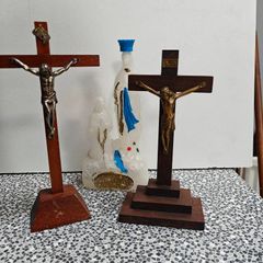 Two crucifixes and a Lourdes Our Lady holy water bottle. Religious devotional items.