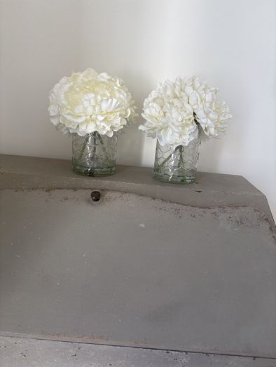 Pair of faux floral decorations with glass vases