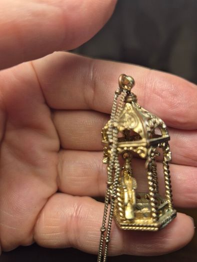 Vintage gilded bird cage with a bird pendant.
