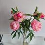 artificial pink flowers in a glass vase Image 2