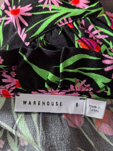 New. Warehouse Size 8 Black Floral print dress with frill trim.
