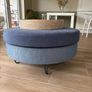 Large Round Blue Ottoman / Footstool with Storage  Stylish round ottoman with a dark denim-blue cushioned top, textured lighter blue base and black metal legs.  The top lifts off to reveal a handy storage space. Perfect as a footstool or styled with a tra Image 2