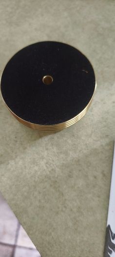 2 Papper Weight , Brass Papper Weight marked ISLAND 12.00 euro. Cleare Risen Tile Papper Weight.with black velvet on the back.10.00 euro.