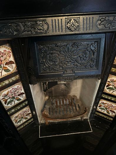 Victorian style cast iron fireplace with floral tiles