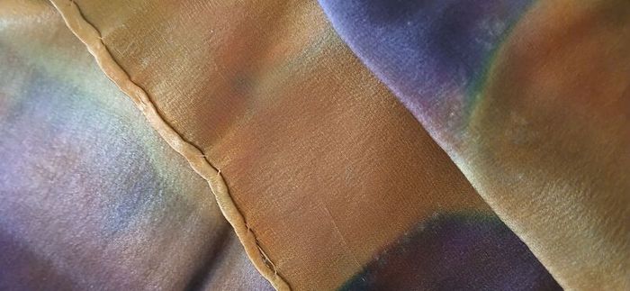 Hand painted, 100% silk scarf featuring a hand-rolled hem and custom metallic gutta detailing.