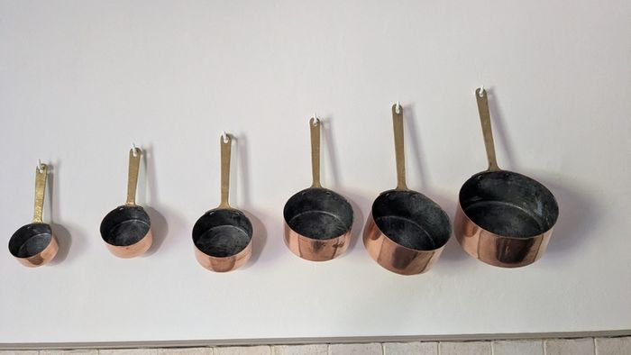 Set of 6 graduated copper saucepans with brass handles