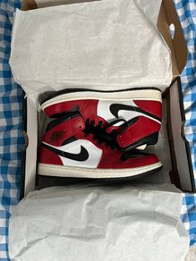 Nike Air Jordan 1 Mid "Chicago Black Toe" sneakers. The iconic black, white, and red colorway is inspired by the original 1985 "Chicago" release