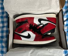 Nike Air Jordan 1 Mid "Chicago Black Toe" sneakers. The iconic black, white, and red colorway is inspired by the original 1985 "Chicago" release