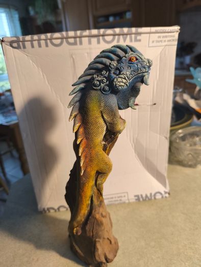 handmade iguana on natural wood log