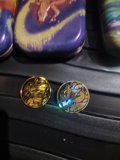 Three Pokemon tins with two coins.