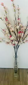 artificial cherry blossom stems in a glass vase