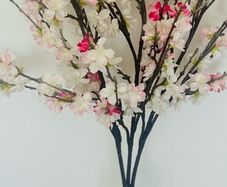 artificial cherry blossom stems in a glass vase
