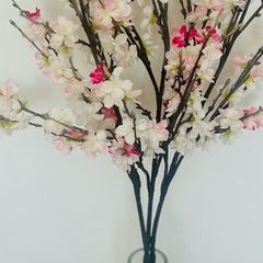 artificial cherry blossom stems in a glass vase