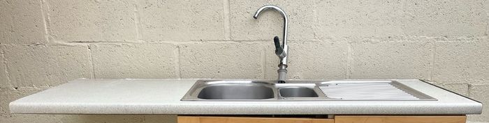 Kitchen sink with countertop and tap