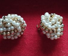 Vintage clip-on earrings with a cluster of faux pearls and gold-tone beads.
